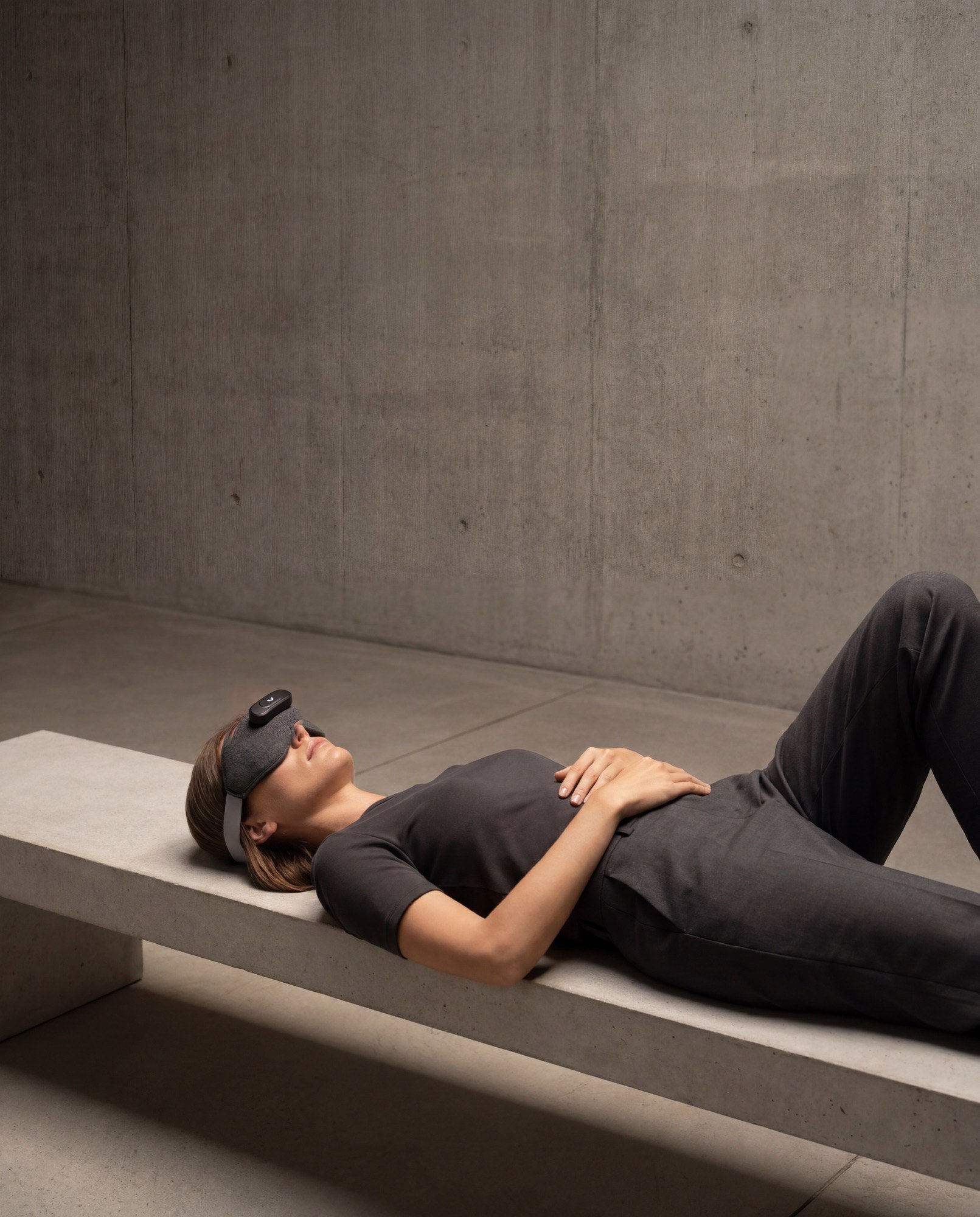 Woman reclining on a stone bench, the Mask over her eyes